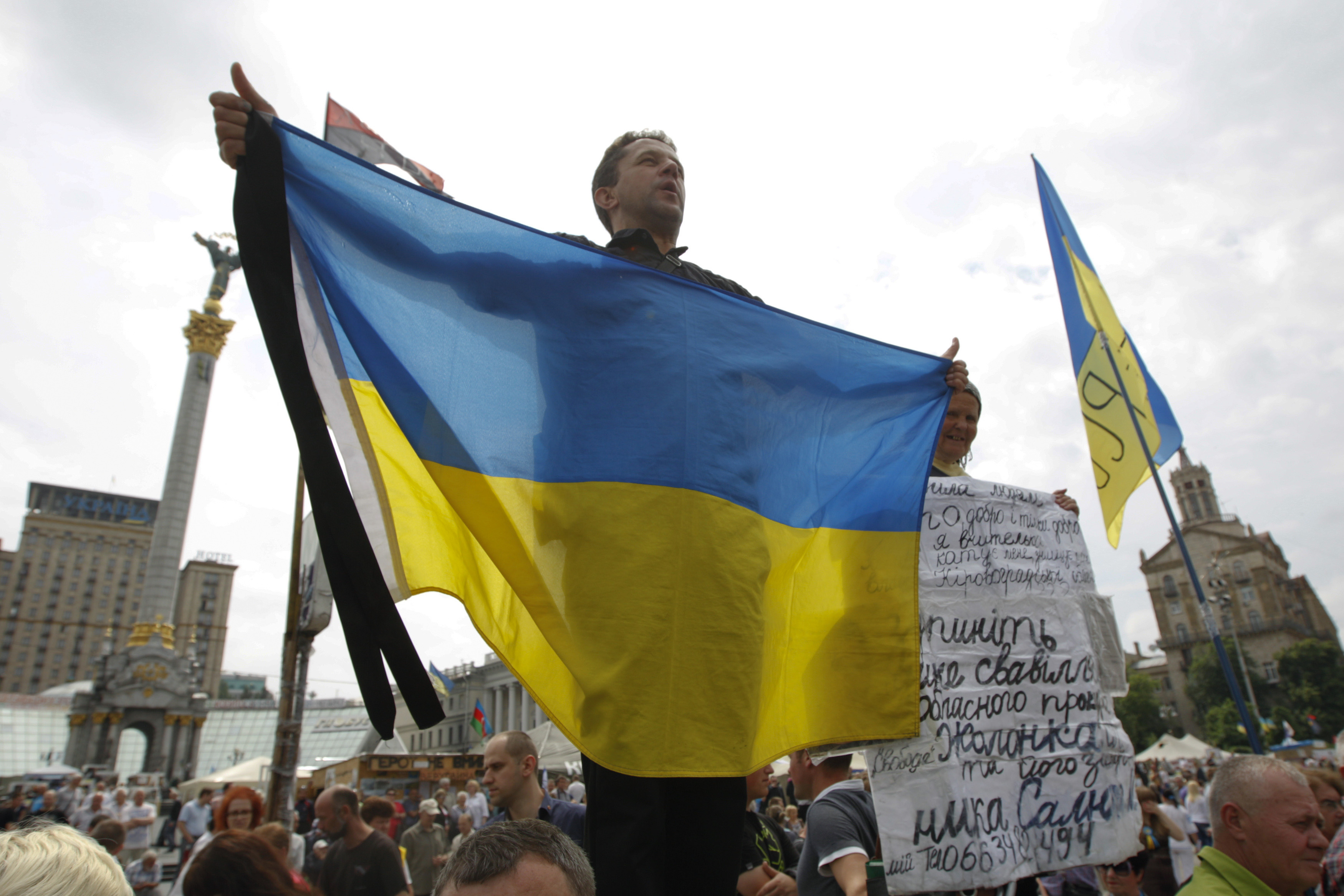 Ukrainians hold flags and signs bearing their latest concerns as they gather in a veche (people’s assembly) at Maidan Nezalezhnosti on Sunday, June 1. The meeting was the latest in a long public debate over the future of the Maidan movement that toppled the corrupt presidency of Viktor Yanukovych in February. REUTERS/Valentyn Ogirenko