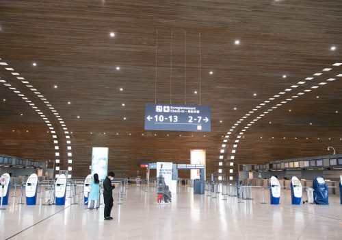 A person wearing protective face mask in an empty Departure Hall at the Terminal 2E of the Paris Charles de Gaulle airport in Roissy, near Paris, France. United States President Donald Trump imposed a 30-day ban on travel from nearly all European countries