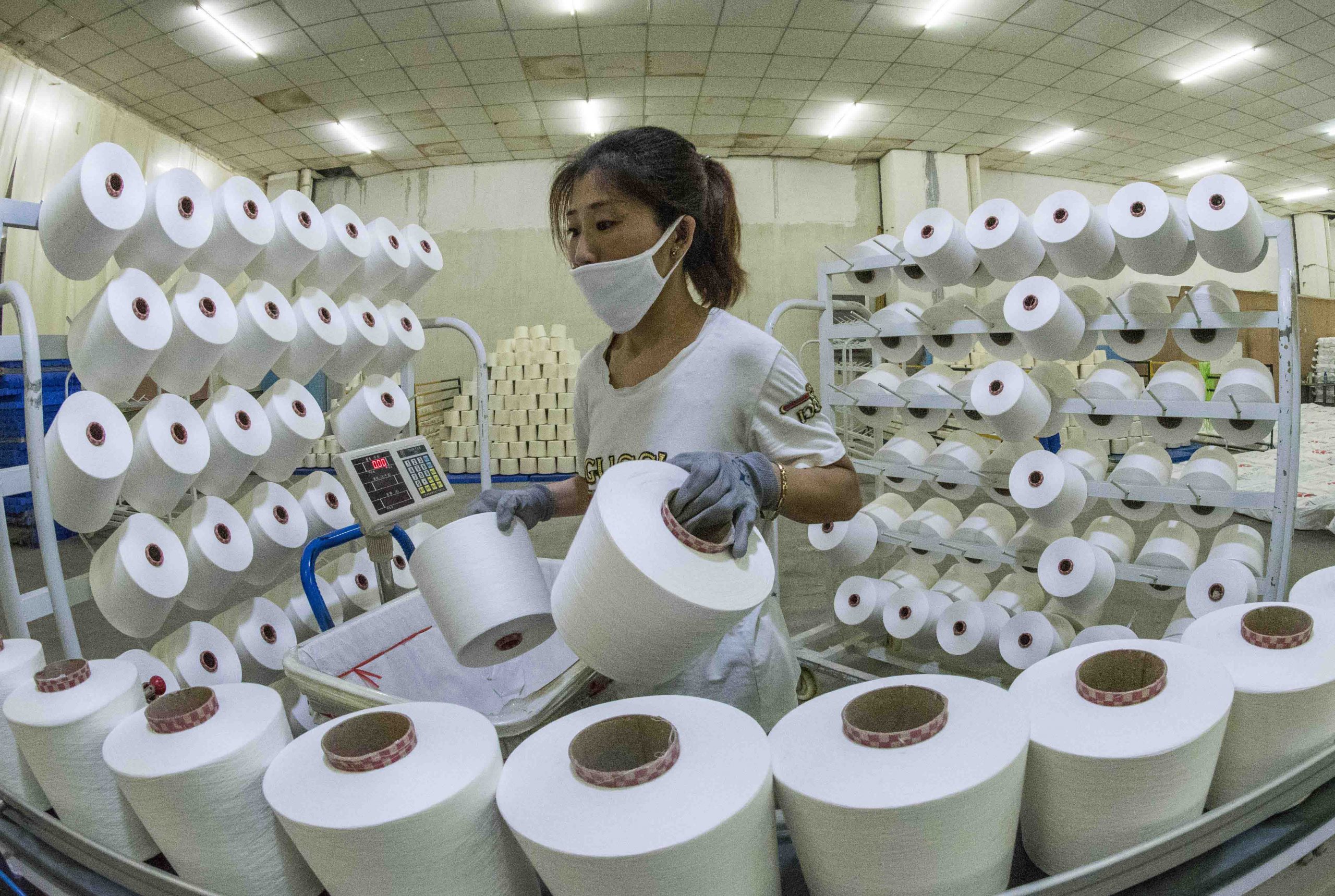 A worker works at a textile factory in Qingzhou city, east China's Shandong province, 18 March 2020.