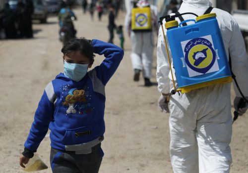 An internally displaced Syrian girl wears a face mask as members of the Syrian Civil defence sanitize the Bab Al-Nour internally displaced persons camp, to prevent the spread of coronavirus disease (COVID-19) in Azaz