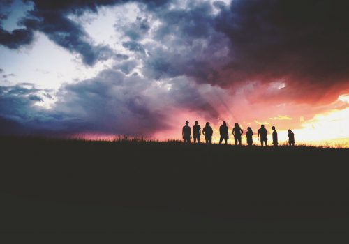 gtc photo of nine people standing on a hill with beautiful clouds in the background