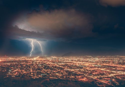 trouble ahead photo of a lightning storm at night over a city