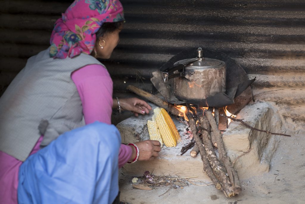 woman cooking over wood fire