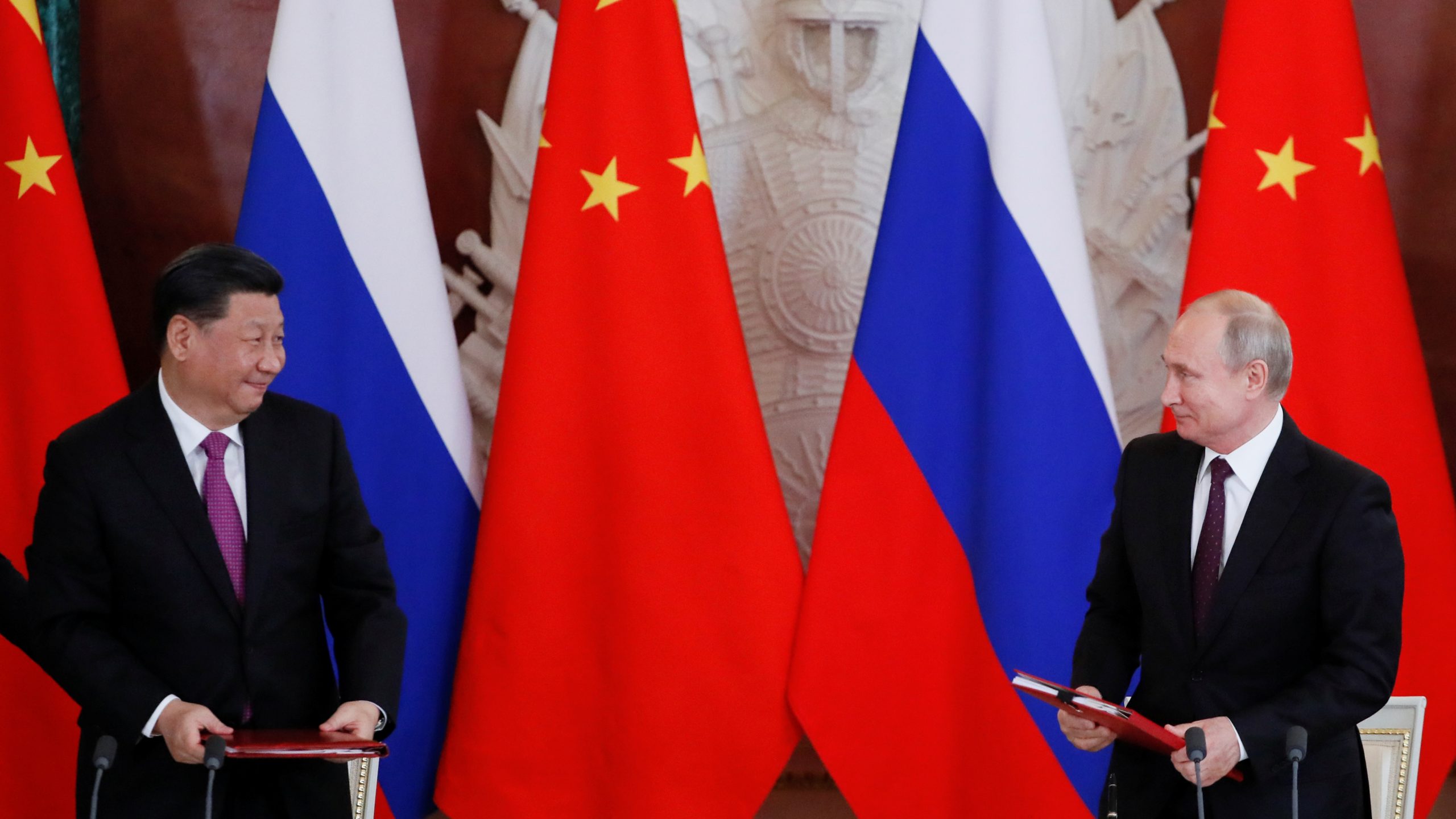 President of Russia Vladimir Putin and President of China Xi Jinping look on during a signing ceremony.