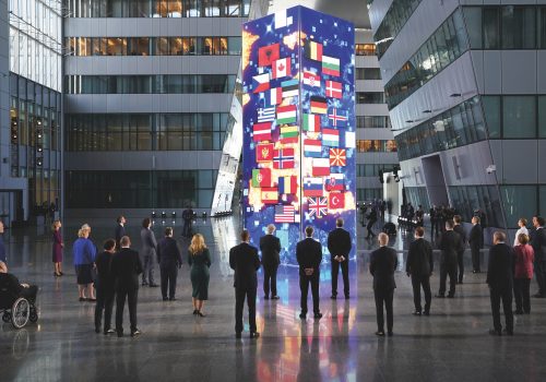 People staring at a pillar covered in flags