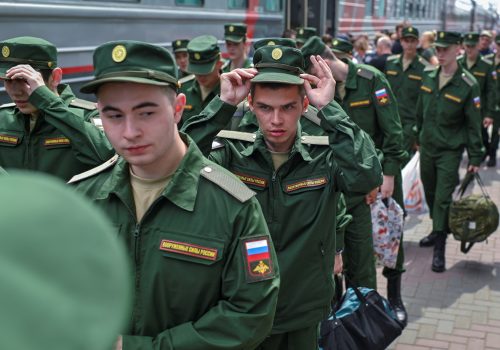 Conscripts board a train carriage at a local railway station during their departure for the garrisons, in Omsk