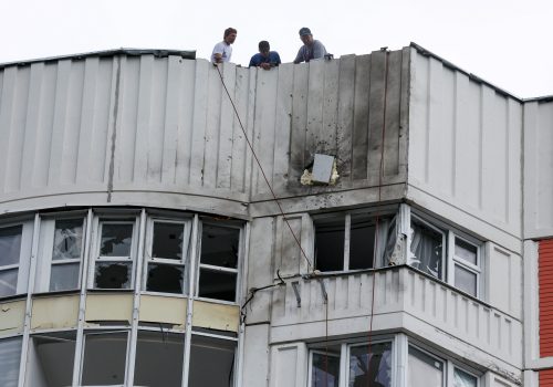 Caption: Men are seen on the roof of a damaged apartment block following a reported drone attack in Moscow, May 30, 2023. (Source: Reuters/Maxim Shemetov)