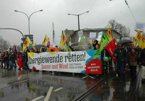 Protesters in Germany hold a sign reading "Save the energy transition! Sun and wind instead of fracking, coal and nuclear!"