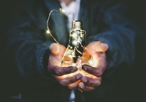 Man holding an incandescent bulb.