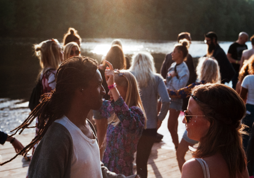 Several people are mingling outside on a sunny day.