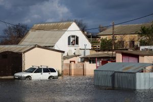 People look out of the window of a house on a flooded street following a storm in the village of Pribrezhe, Crimea November 28, 2023. REUTERS/Alexey Pavlishak