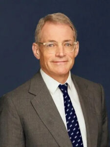Michael Fisch standing at an angle against a navy blue background.