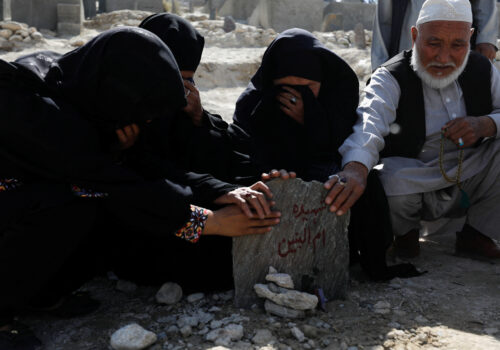 The family members of Um al-Banin, who was killed in a suicide attack in a tutoring center in Dasht-e-Barchi district in the west of Kabul, pray at her grave in Kabul, Afghanistan, October 2, 2022. REUTERS/Ali Khara