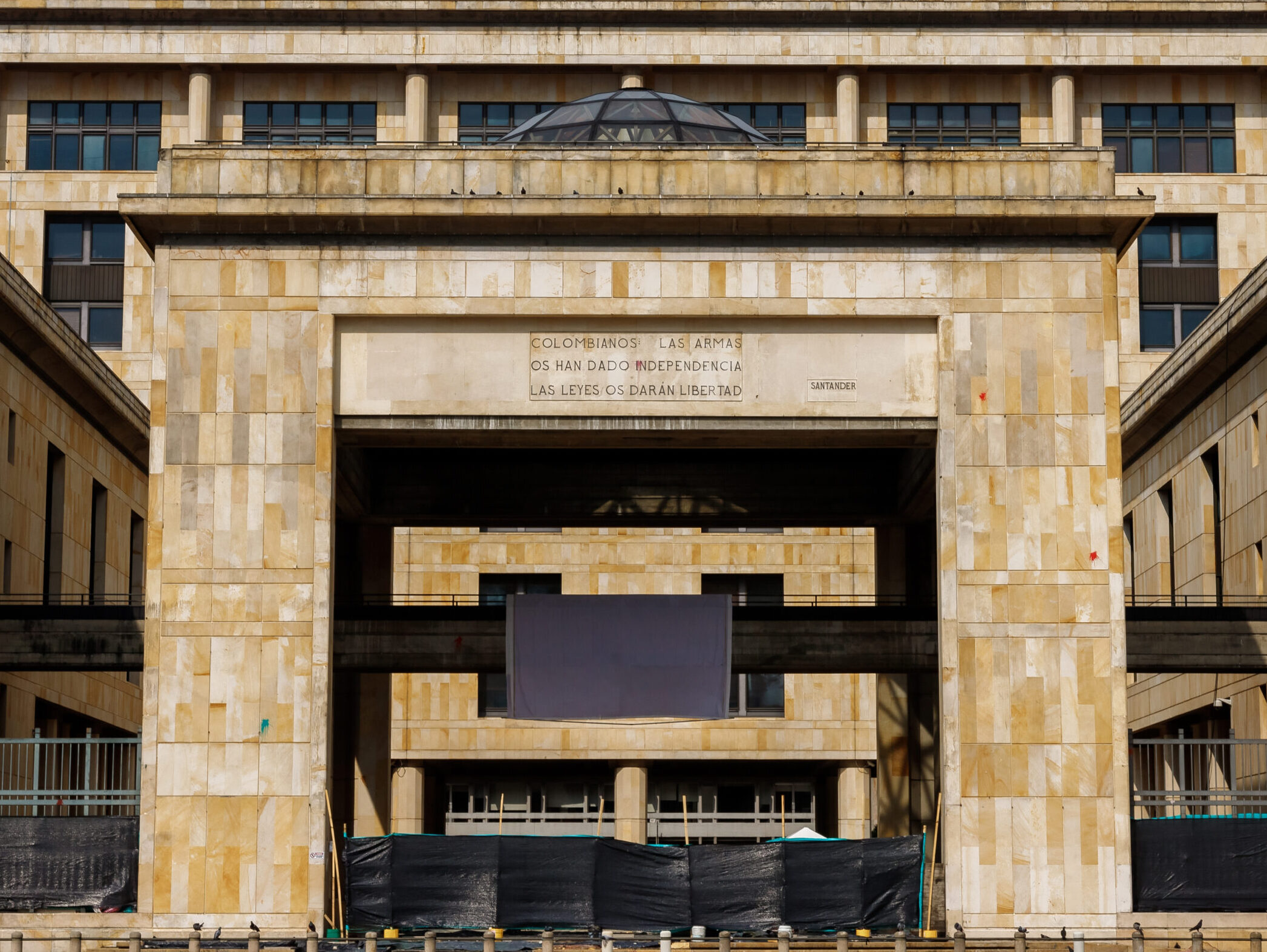 Facade of the Palace of Justice in the main square of Bogota, Colombia with the caption "Colombians, weapons gave you independence, laws will give you freedom."