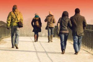 People walking on a bridge into the distance.