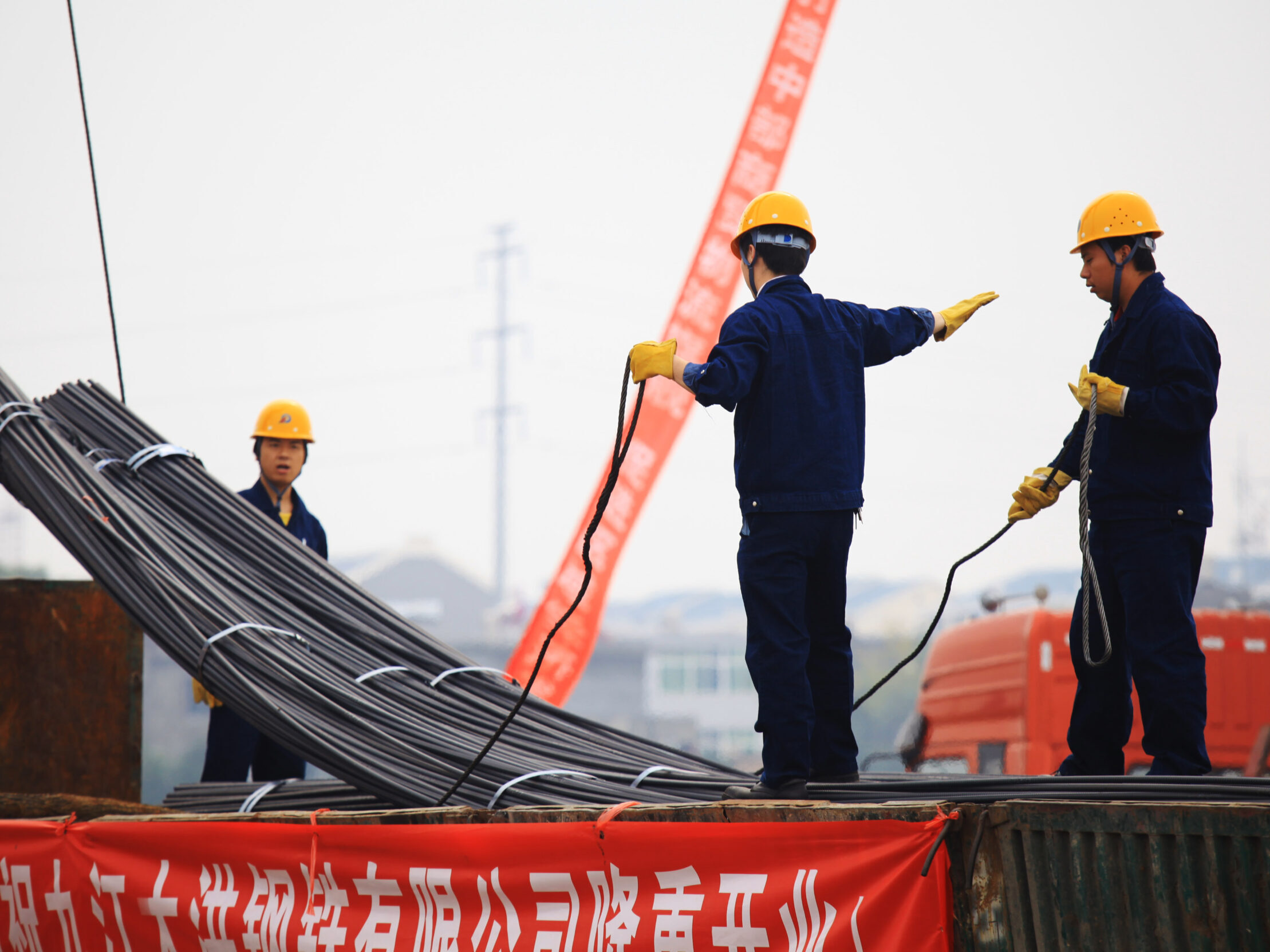 In China's eastern city of Jiujiang, workers in the steel building materials market hoisting steel.