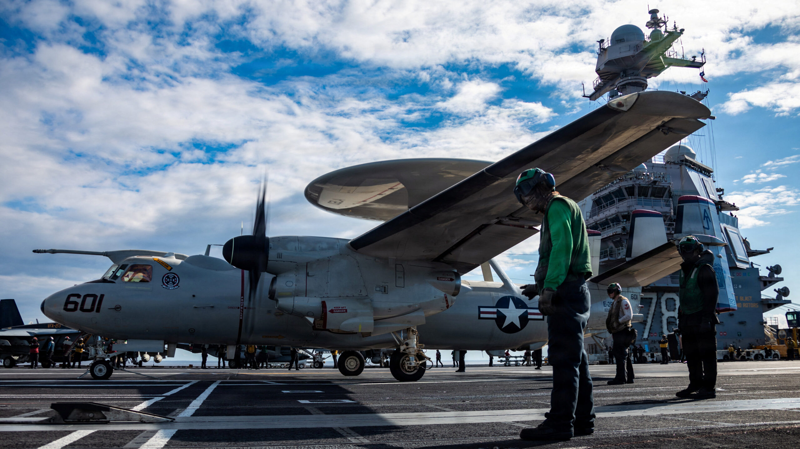 Man-standing-next-to-airplane-on-carrier