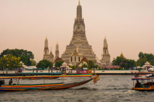 Boats and tourists around Wat Arun in Bangkok.