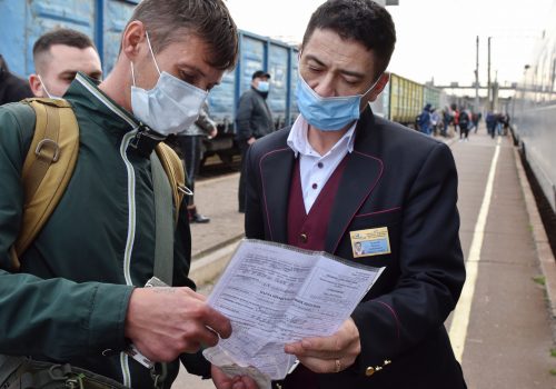 A passenger is seen showing his vaccination document to a train conductor in Ukraine, October 21, 2021. A vaccination certificate or a negative test is required for inter-city travel by train, bus or planes.