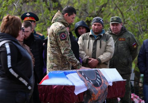 A Russian serviceman mourns next to the coffin of Savely Shashkov, a member of the Russian military volunteer unit "Immortal Stalingrad", who was killed during Russia-Ukraine conflict, at a cemetery in the town of Krasnoslobodsk in the Volgograd Region, Russia April 15, 2023. REUTERS/Kirill Braga