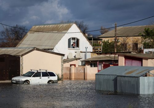 People look out of the window of a house on a flooded street following a storm in the village of Pribrezhe, Crimea November 28, 2023. REUTERS/Alexey Pavlishak